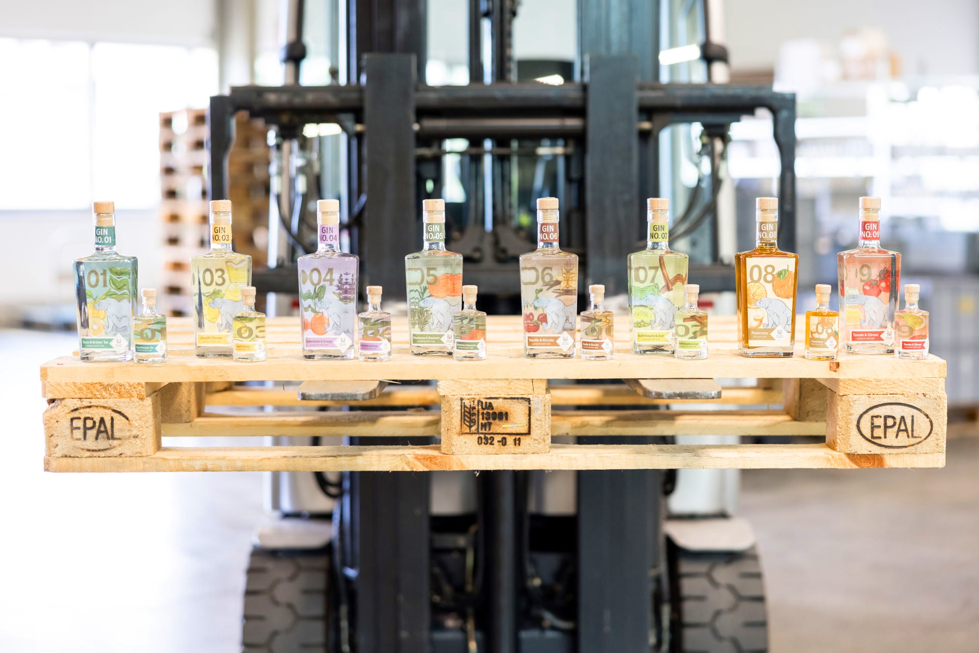 Inge und der Honigbär Gin-ortiment große und kleine Flaschen auf Palette