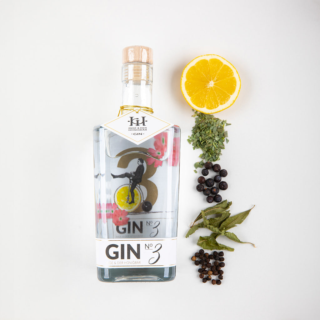 Ingredients liegen neben einer Flasche Premium-Gin NO. 3 Amalfi-Zitrone von Inge und der Honigbär, auf weißem Hintergrund.