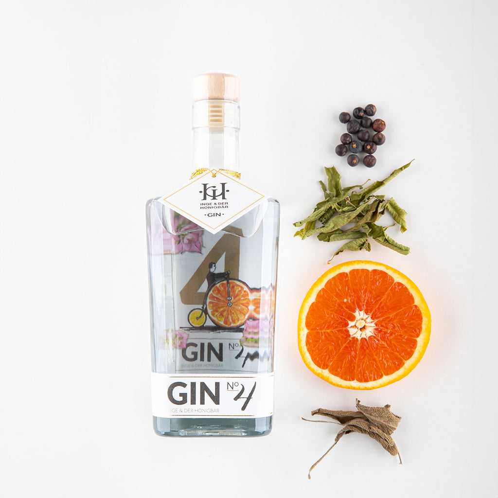 Ingredients liegen neben einer Flasche Premium-Gin NO. 4 Salbeiblüte & Orange von Inge und der Honigbär, auf weißem Hintergrund.