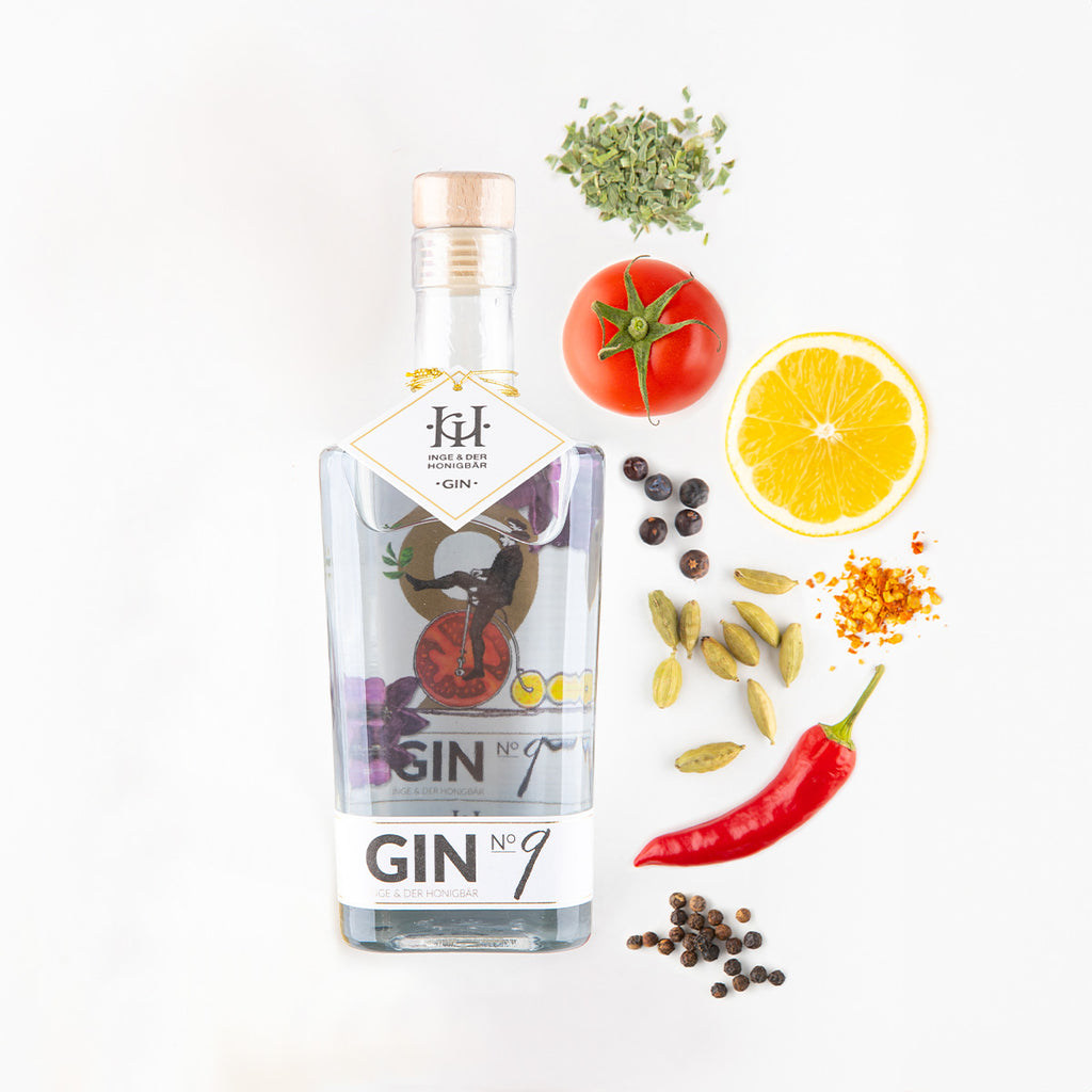 Ingredients liegen neben einer Flasche Premium-Gin NO. 9 Tomate & Zitrone von Inge und der Honigbär, auf weißem Hintergrund.