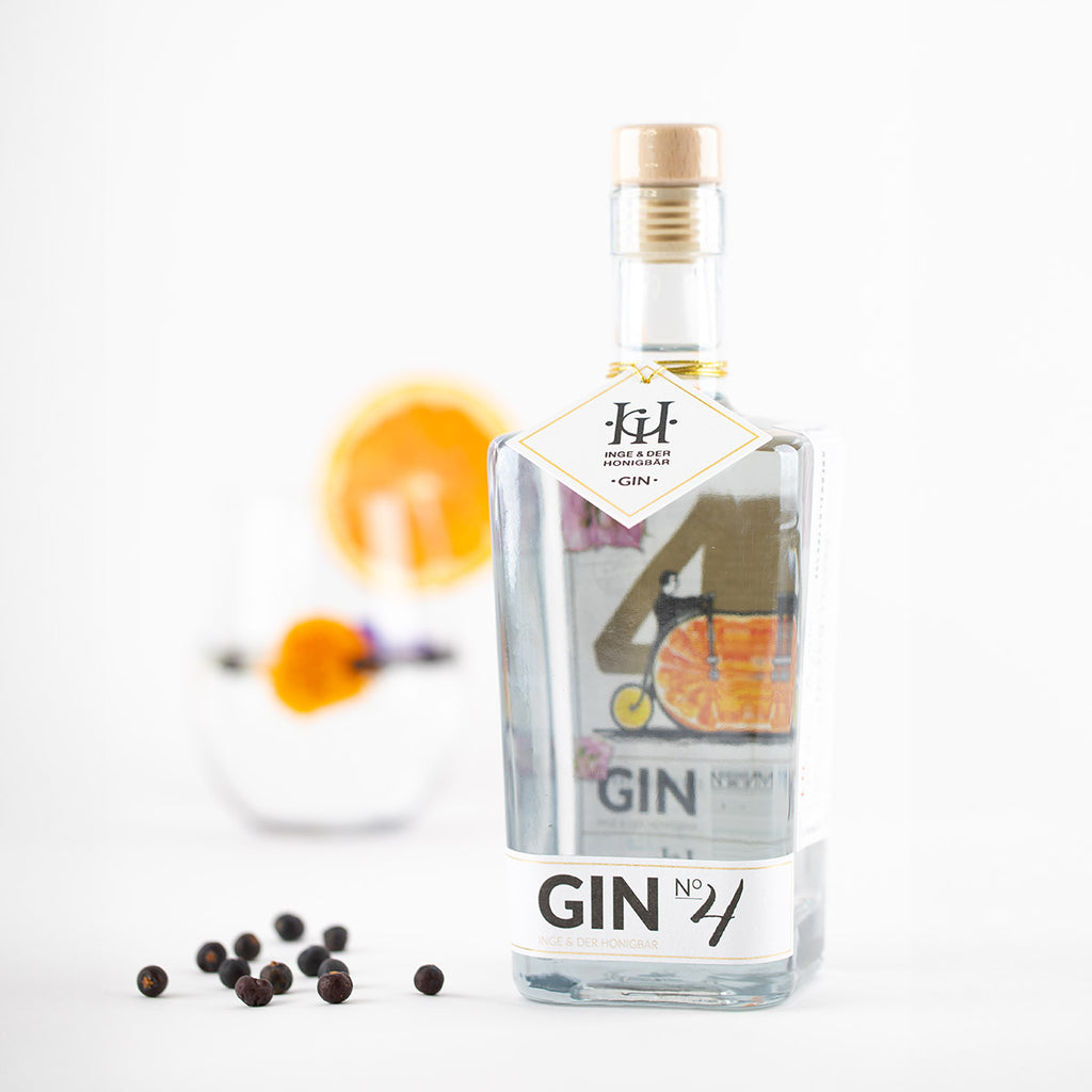 Eine Flasche des regionalen Premium-Gins NO. 4 von Inge und der Honigbär, umringt von hochwertigen Zutaten wie Orange und Wacholder.