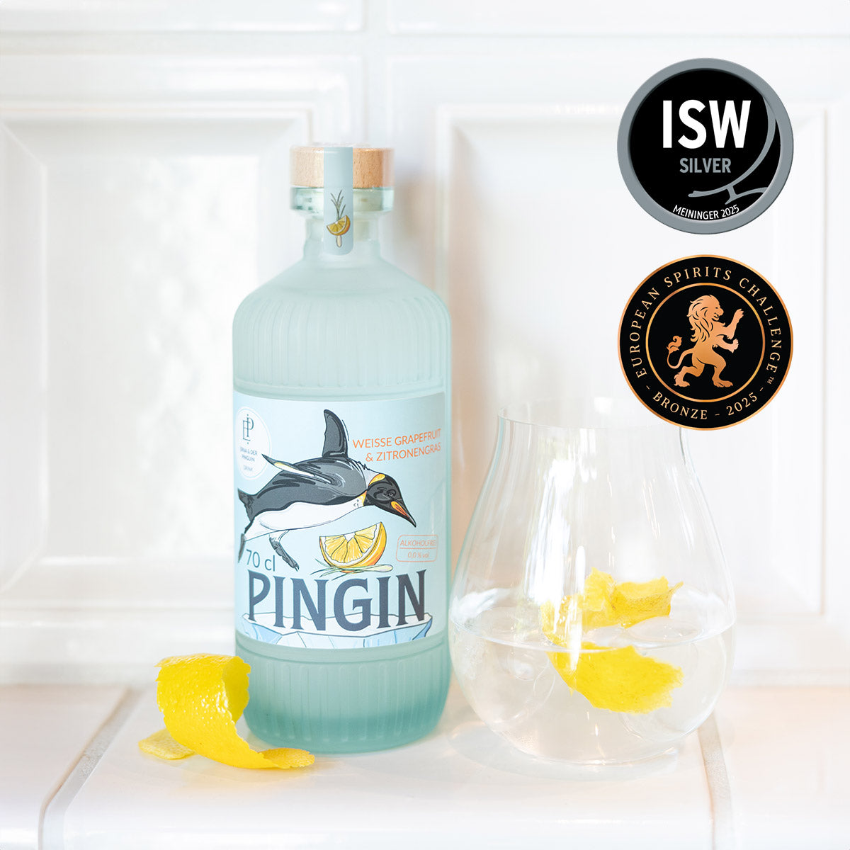Ein Glas mit Zitronen und eine Flasche der alkoholfreien Gin-Alternative Pingin von Erna und der Pinguin.