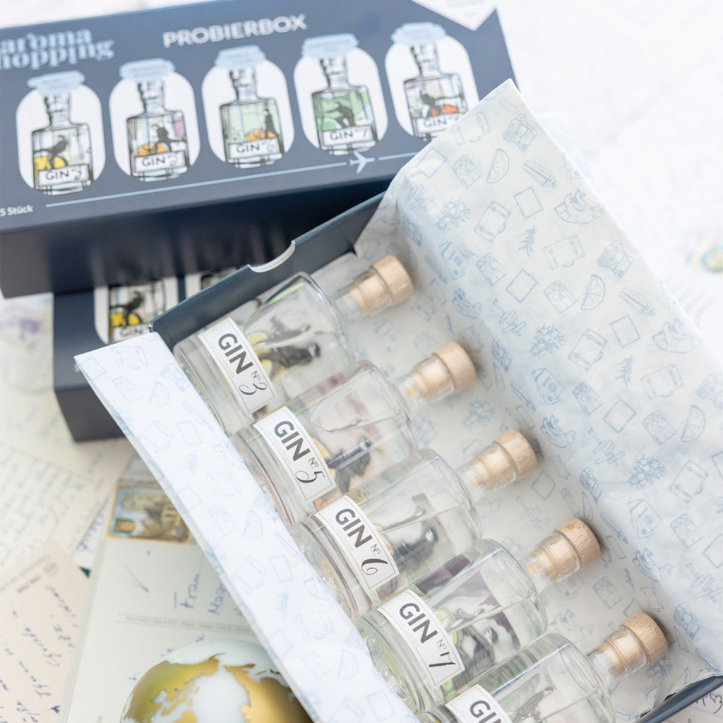 Innen- und Außenansicht der Aromahopping Probierbox mit fünf kleinen Premium-Gins zum Probieren.